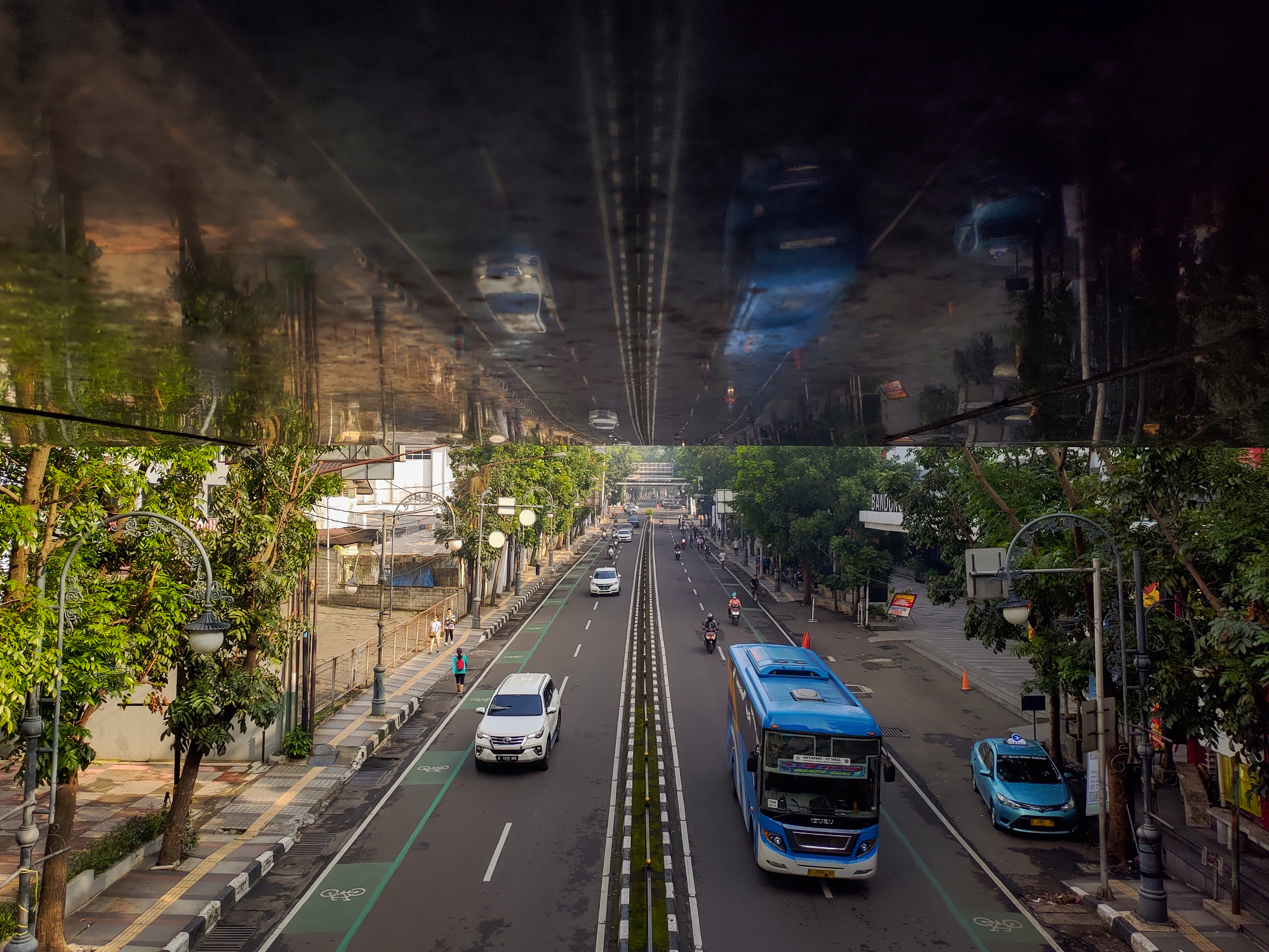 A quiet urban street in the morning captured from above with a dramatic ceiling reflection doubling the scene