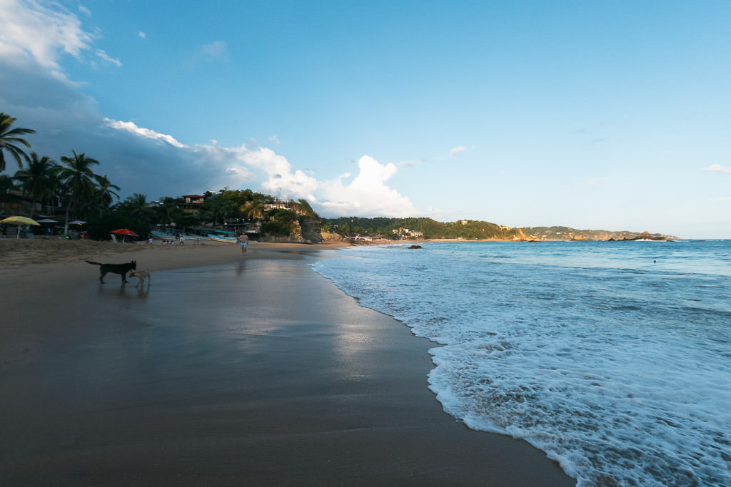 A wide shot of Mazunte's main beach in Oaxaca, Mexico, at late afternoon or early morning