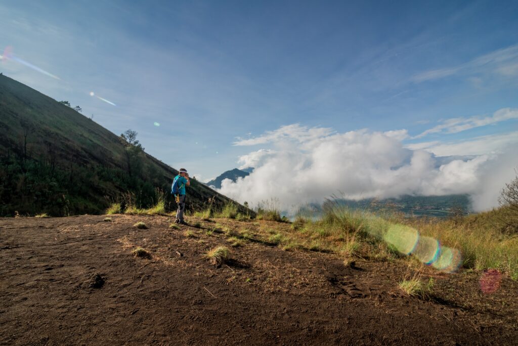 A hiker crossing rocky obstacle in the mountains in Bali