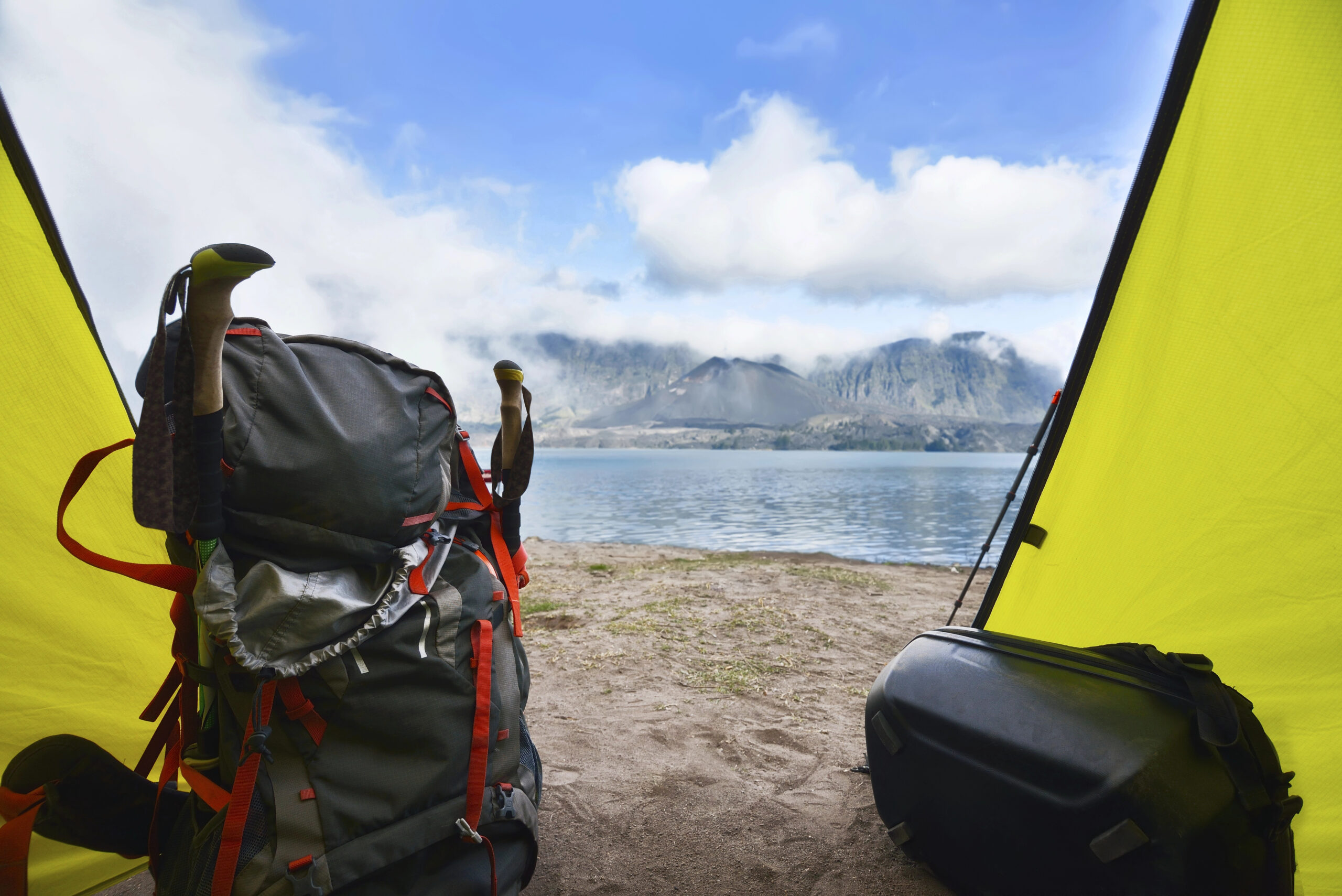 Hiker backpack in the tent with segara anak lake view inside the caldera of Mount Rinjani in Lombok, Indonesia