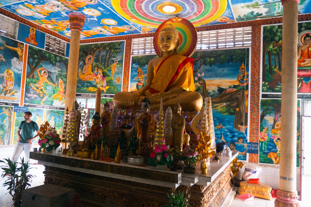 A large golden Buddha inside a colorful temple