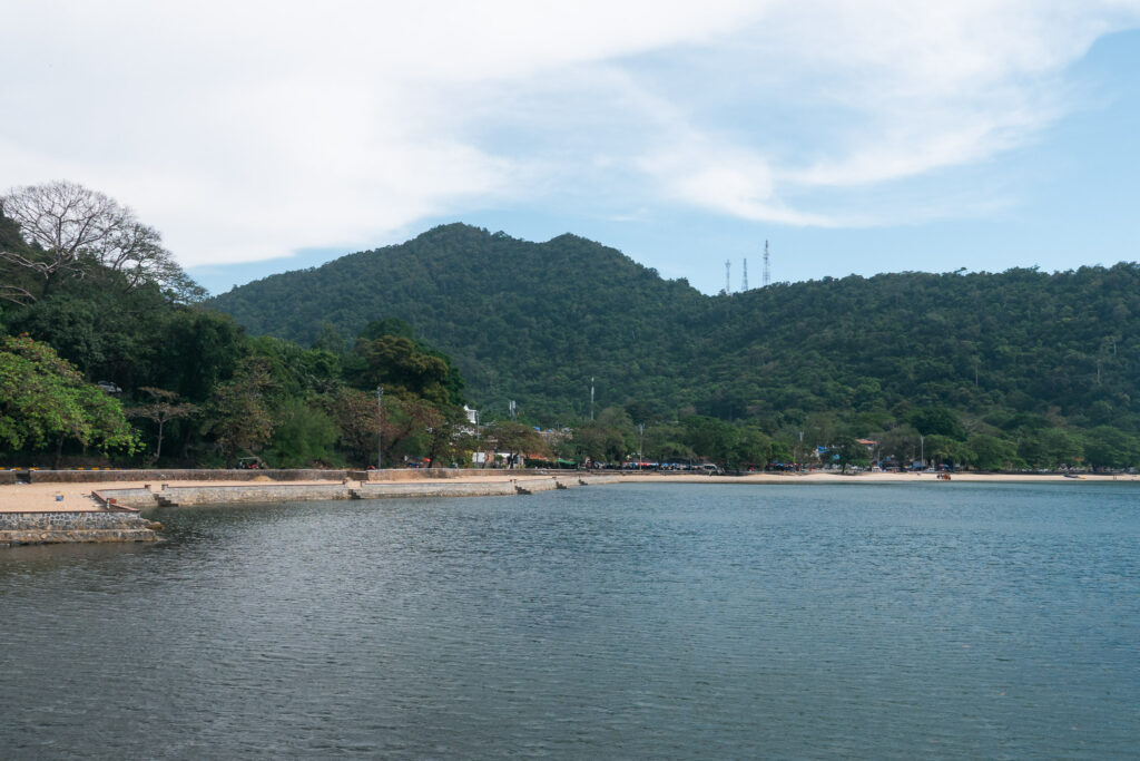 kep beach with a green mountain in the background