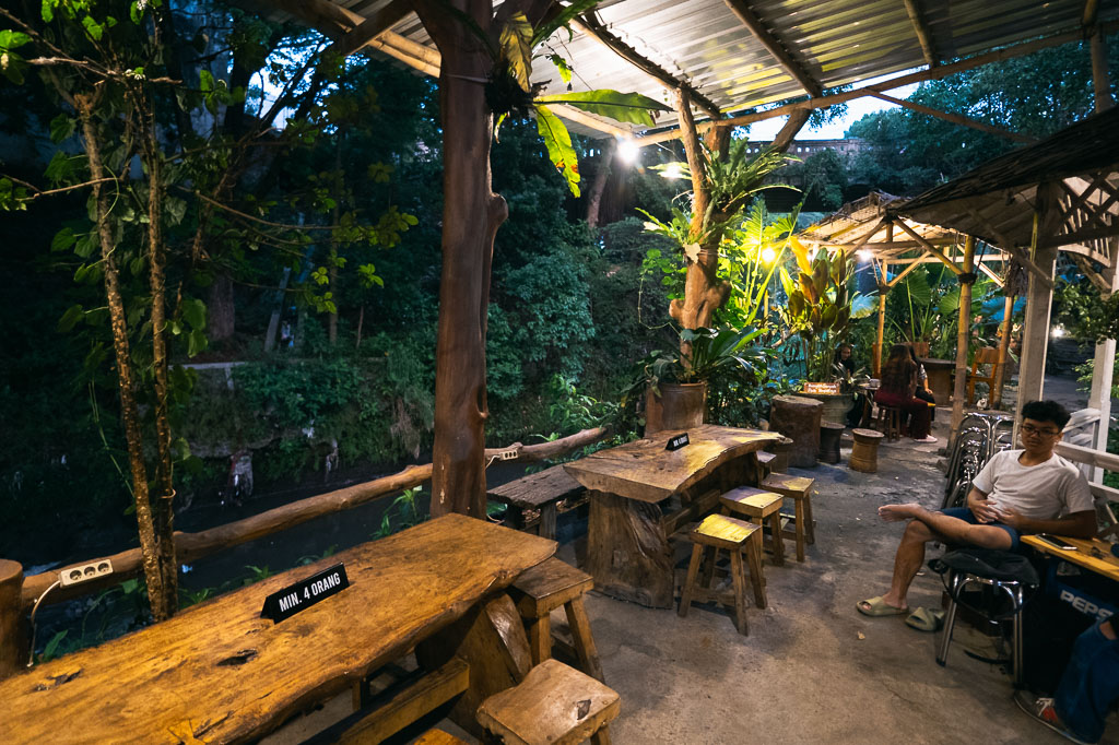 Outdoor dining spot in Malang with wooden tables and greenery