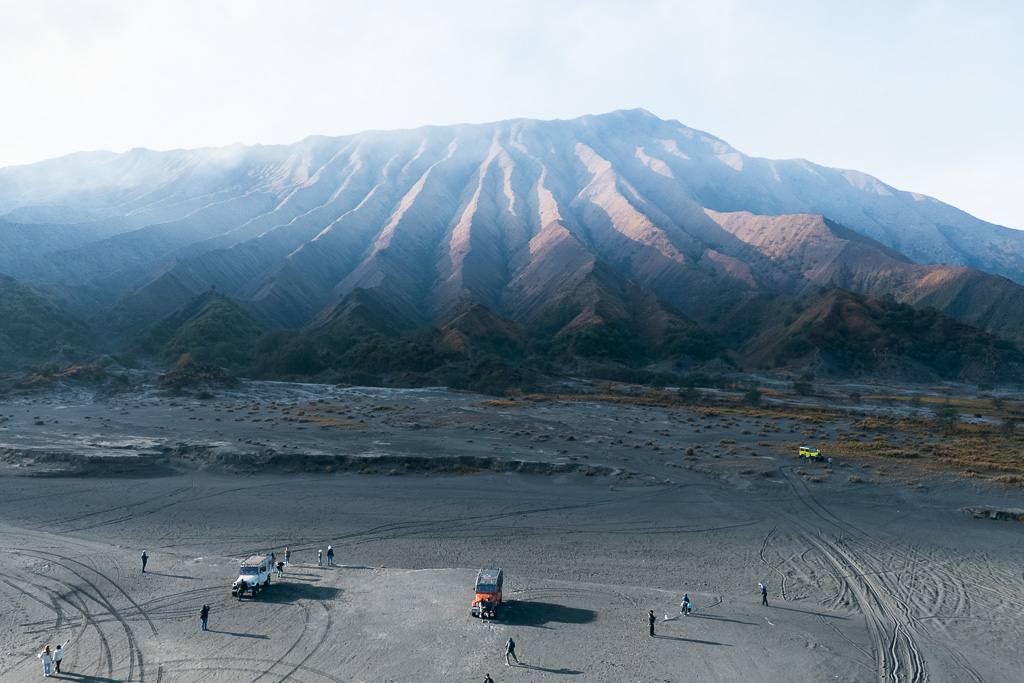 View of the barren, volcanic plains surrounding Mount Bromo, with the mountain dominating the background