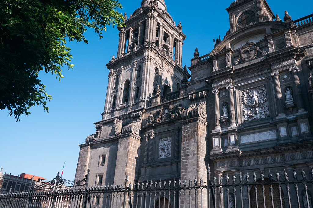 A low-angle view of the ornate stone facade of the Mexico City Metropolitan Cathedral