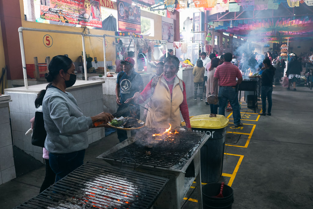 Vendors grilling meats and serving customers in Pasillo de Humo in Oaxaca’s Mercado 20 de Noviembre