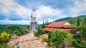 A temple with a giant statue on the mountains of Dalat, Vietnam on a cloudy day.