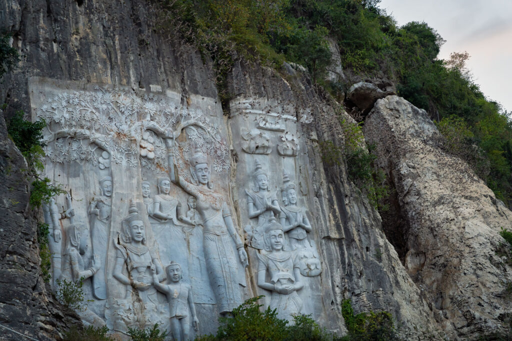 A close-up view of ancient statues adorning the walls of the Bat Cave in Battambang, Cambodia