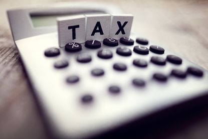 closeup of calculator with the word tax written out on blocks