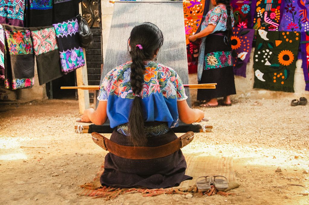 A woman working on a loom, textile