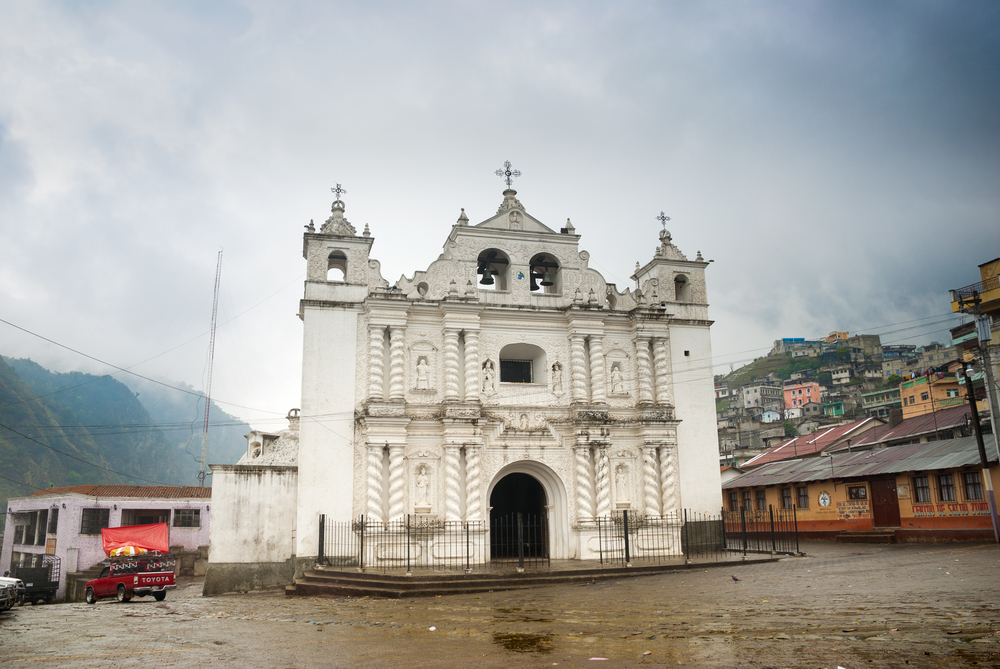 A white church building in Xela, Guatemala on a cloudy day.